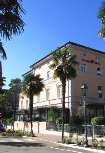 Hotel elegante con palme e montagne sullo sfondo.